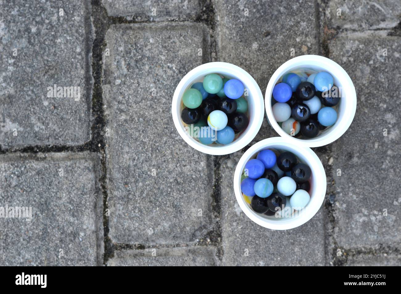 Toy marmi seme su tre tazze di colore bianco Foto Stock