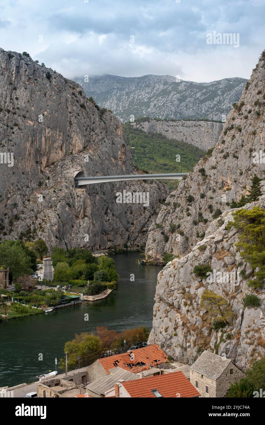 Il ponte Omis si estende lungo il fiume Cetina in Croazia, con tunnel panoramici e un ponte con vista sulle montagne. Foto Stock