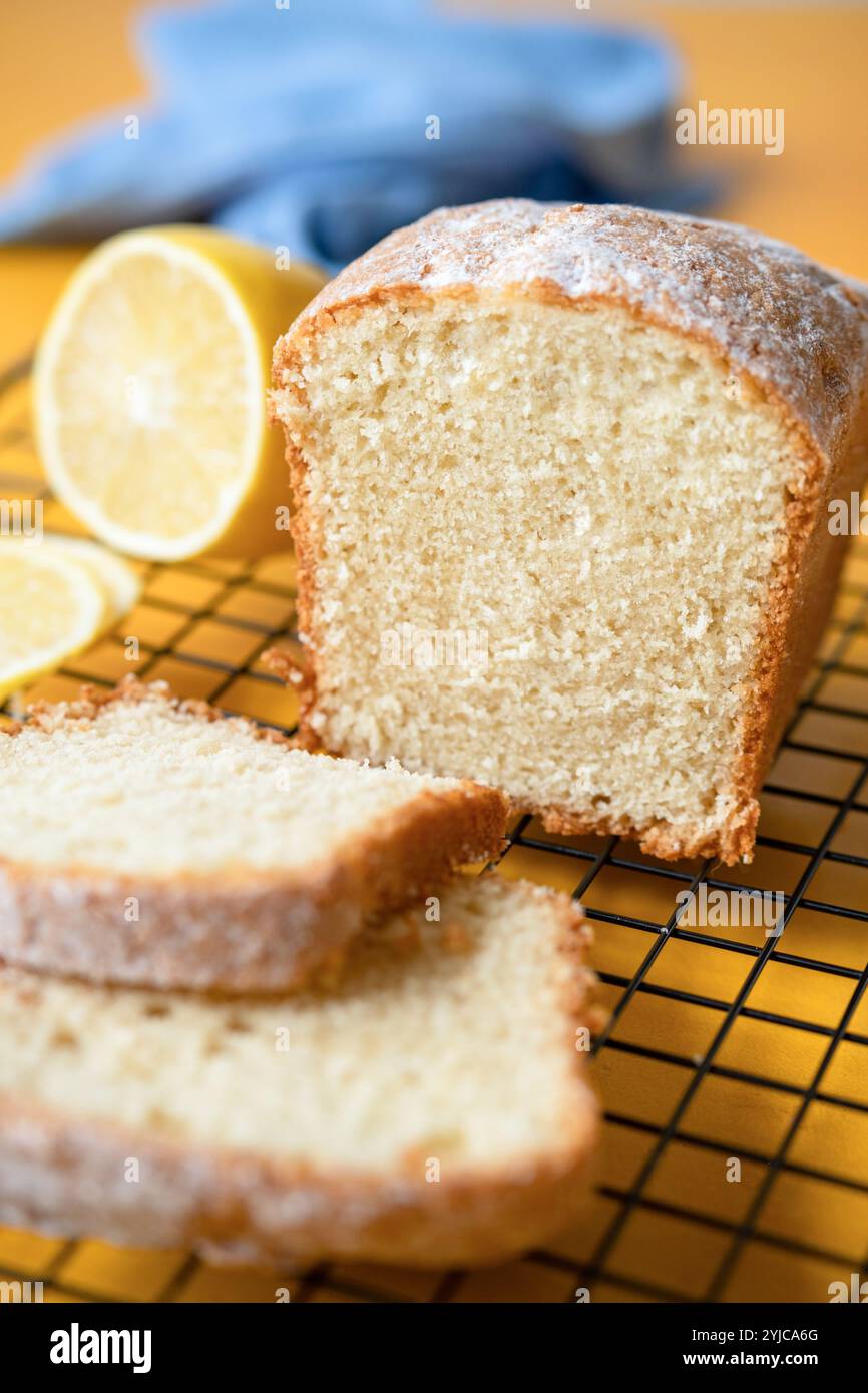 Torta al limone affettata su una griglia di raffreddamento, vista ravvicinata della deliziosa consistenza della torta soffice Foto Stock