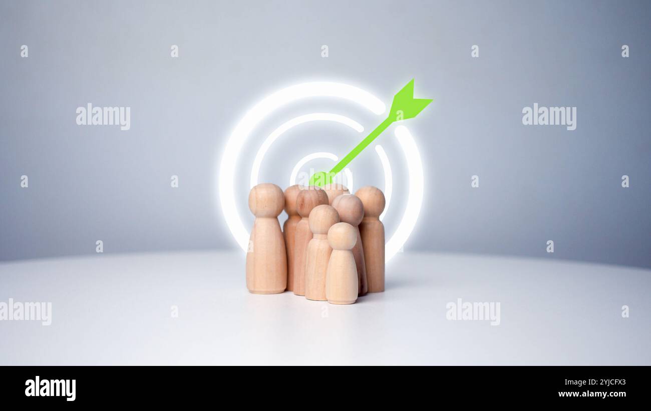 Obiettivo del concetto di azienda e del personale in un'azienda. bambole di legno in piedi intorno al bordo di freccette per la creazione e il targeting degli obiettivi aziendali. Marketi Foto Stock