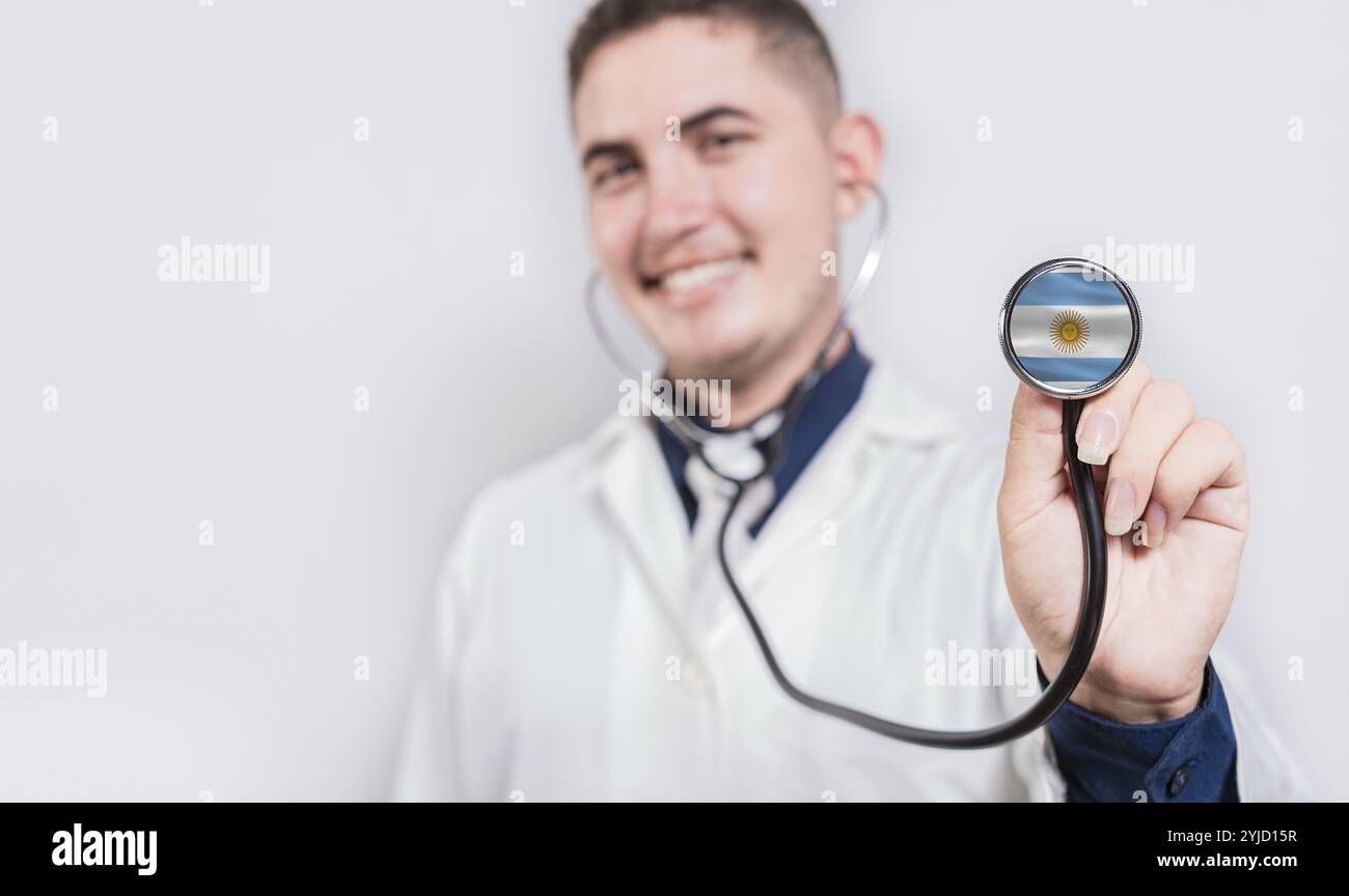 Medico sorridente mostrando stetoscopio con bandiera Argentina. Argentina National Healthcare Concept Foto Stock