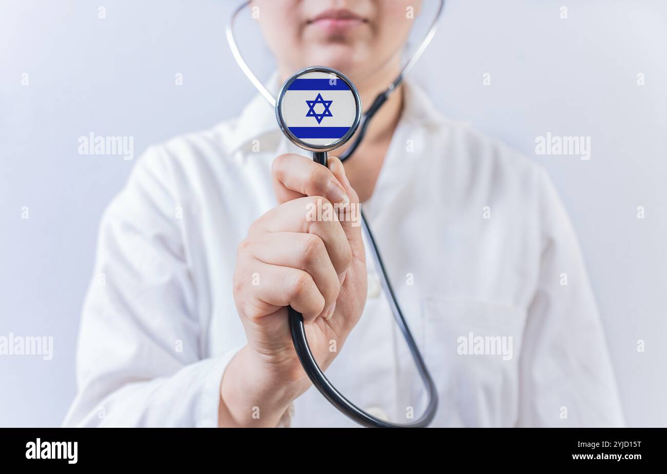 Medico che mostra lo stetoscopio con la bandiera di Israele. Concetto di assistenza sanitaria nazionale israeliana Foto Stock