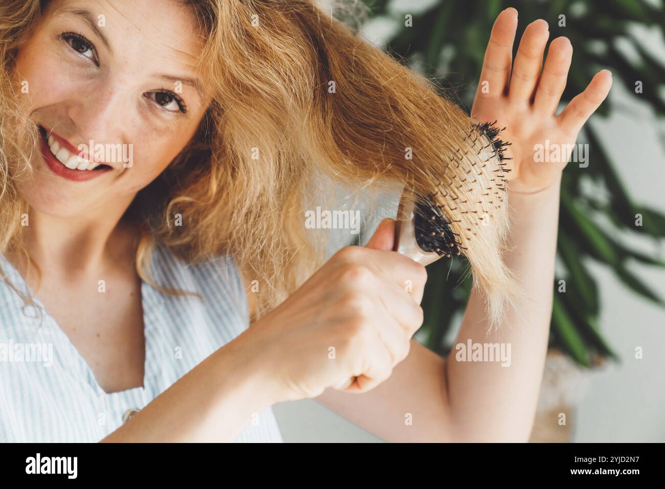 Concetto di autoassistenza. Ritratto di una donna adulta attraente che cura la pelle e i capelli a casa. Bellezza a casa. Donna che fa il trucco, si pulisce i capelli. Foto Stock