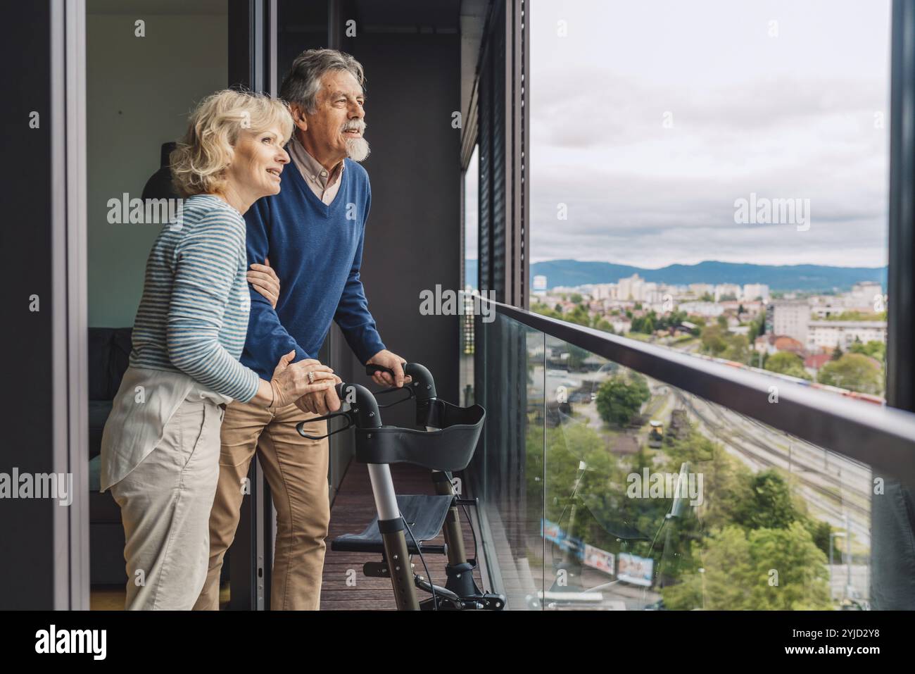 Una coppia di anziani sposati sul balcone che si affaccia sulla città. Foto Stock