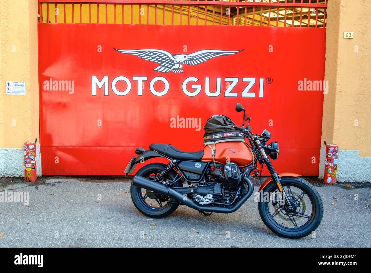 Ein Motorrad der Marke Moto Guzzi Modell V7 steht vor dem Werkstor bei Moto Guzzi a Mandello del Lario, Lombardei, italien Fahrt nach Mandello mit Guzzi *** Una moto Moto Guzzi modello V7 si trova di fronte al cancello della fabbrica Moto Guzzi a Mandello del Lario, Lombardia, Italia Ride to Mandello con Guzzi Foto Stock