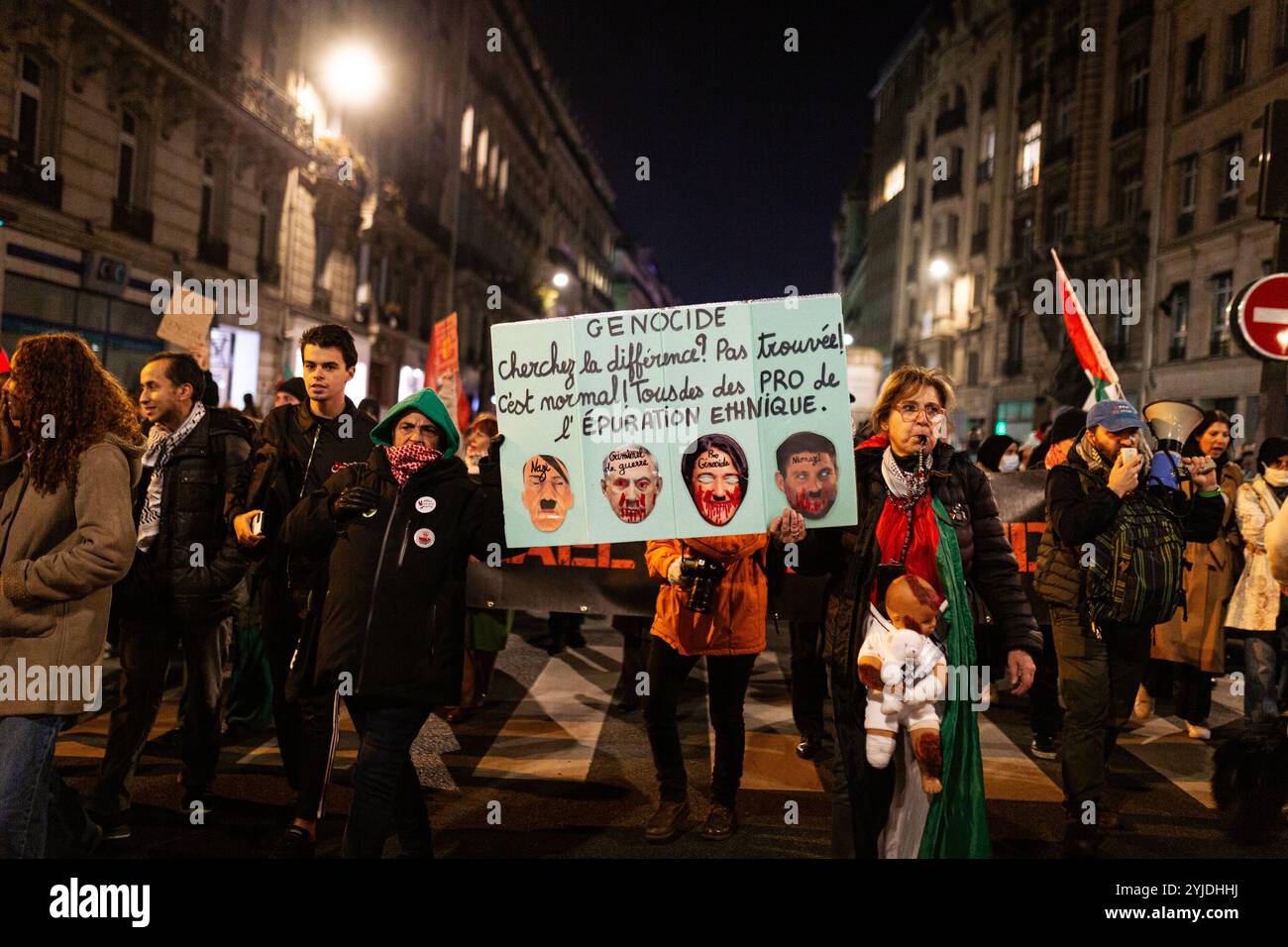 I manifestanti hanno un cartello con scritto "genocidio” e con i volti di Hitler e Benjamin Netanyahu, durante la manifestazione pro-palestinese contro l'organizzazione del gala pro-Israele "Israele è per sempre” a Parigi. Migliaia di persone hanno manifestato a Parigi contro il gala organizzato dall’estrema destra a sostegno di Israele, “Israele è per sempre”. La manifestazione, sotto una forte sorveglianza della polizia, è stata organizzata da partiti di sinistra e sindacati, movimenti ebraici di sinistra e gruppi filo-palestinesi. Bezalel Smotrich, il ministro delle Finanze israeliano, noto per le sue posizioni estreme su Gaza, che lo era Foto Stock