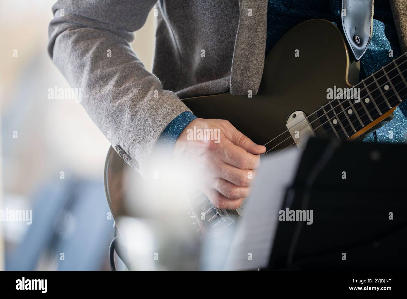 Chitarrista sul palco per il concetto di sottofondo, morbido e sfocato. Primo piano mano che suona la chitarra. Musicista che suona la chitarra, musica dal vivo di sottofondo. Foto Stock