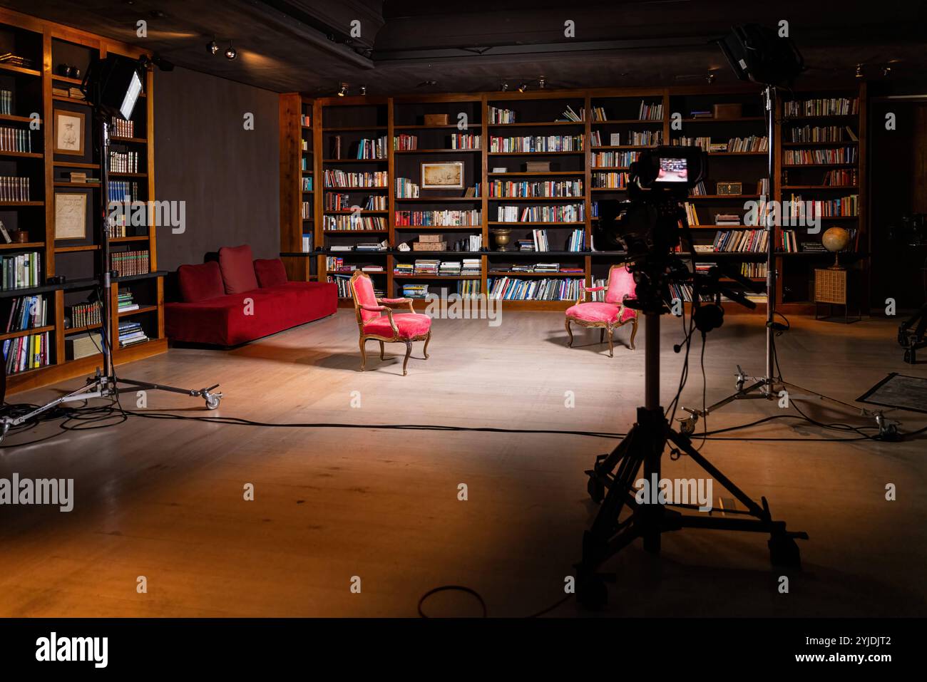 Configurazione professionale per interni per un'intervista televisiva con telecamere e comode sedie in una libreria Configurazione professionale per interni per un'intervista televisiva con telecamera Foto Stock