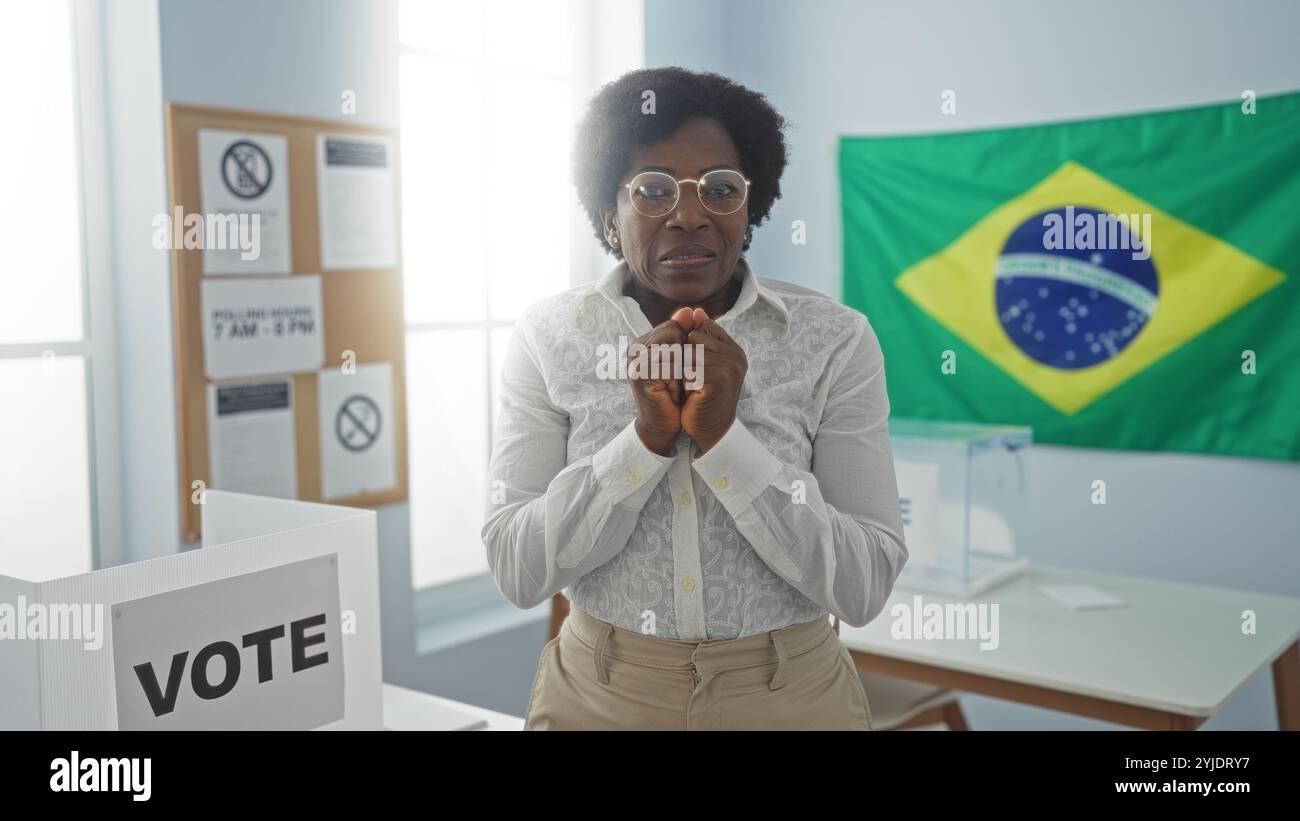 Bella donna afroamericana con capelli ricci in una sala universitaria elettorale in brasile con una bandiera brasiliana sullo sfondo Foto Stock