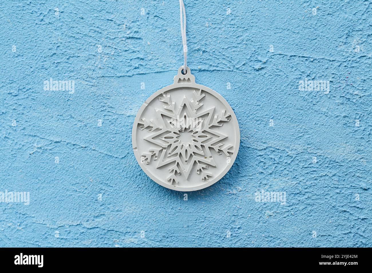 Pietra con fiocco di neve, placca o calcestruzzo. Maggiore durata al gelo quando indurito. Palla di Natale in cemento e gesso su zampe blu Foto Stock