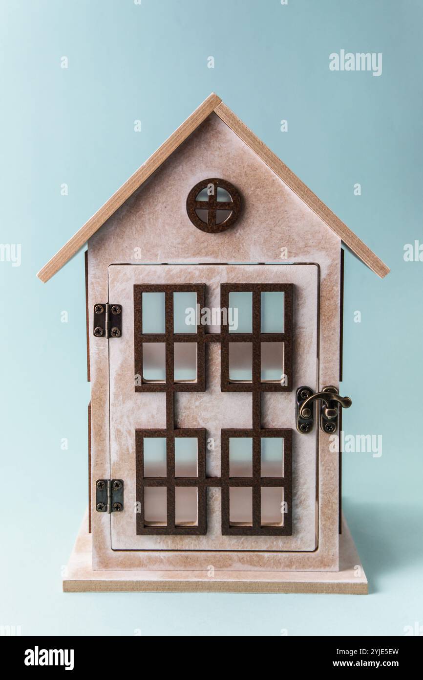 Candeliere rustico fatto a mano. Casa in legno con finestre su sfondo blu. Concept fai da te Foto Stock