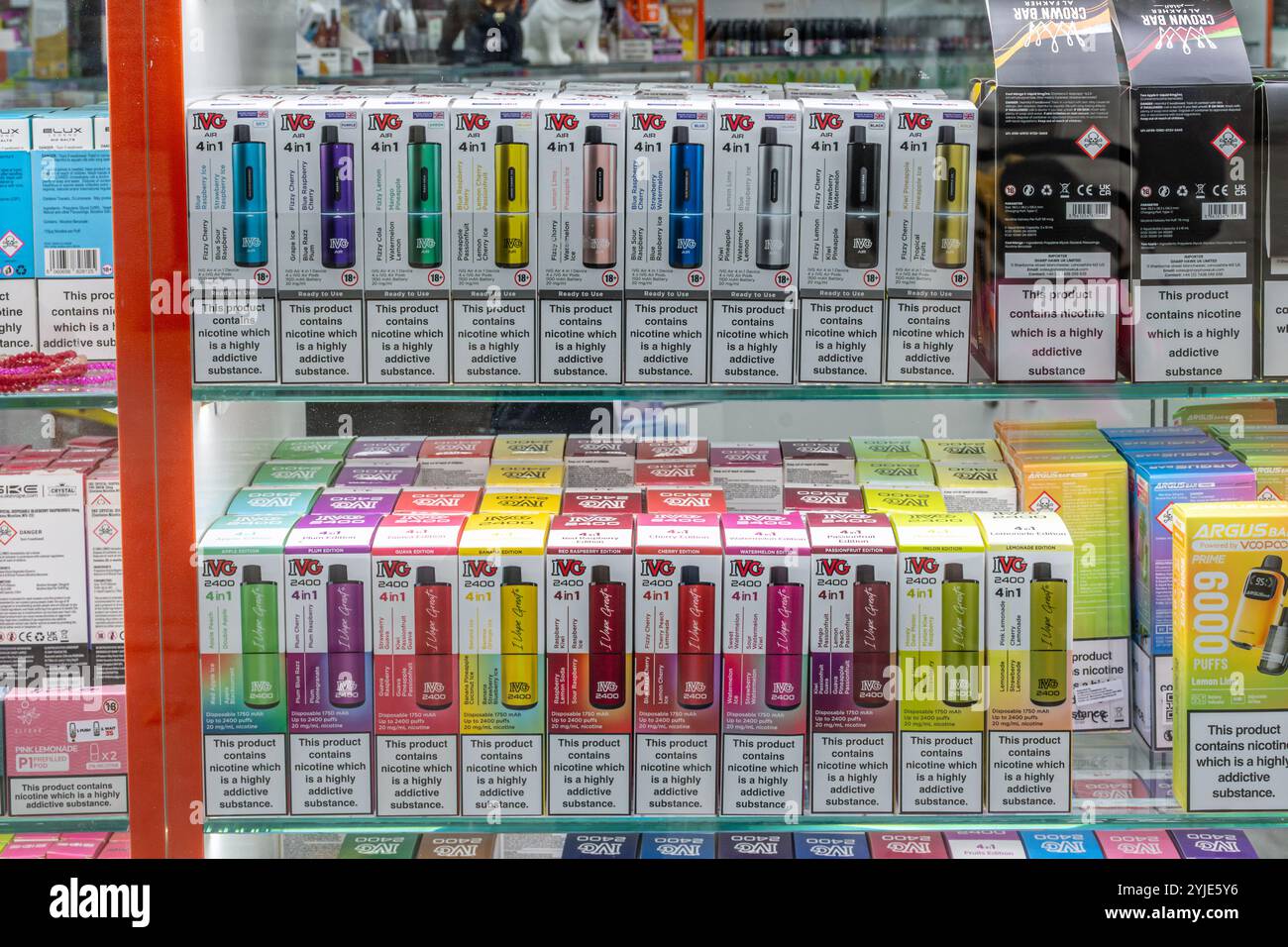 Esposizione di vapori colorati in una vetrina con una varietà di sapori di frutta, Inghilterra, Regno Unito. Concetto: Vaping giovanile, prodotti attraenti per i bambini Foto Stock