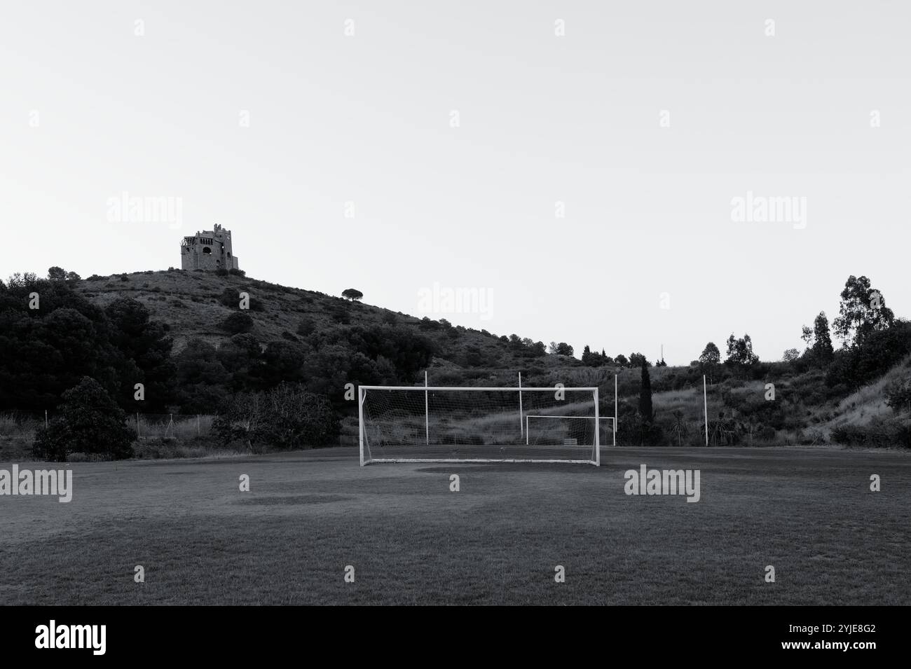 La silhouette di Castillo de la Mota in cima a una collina contrasta con un campo da calcio vuoto Foto Stock