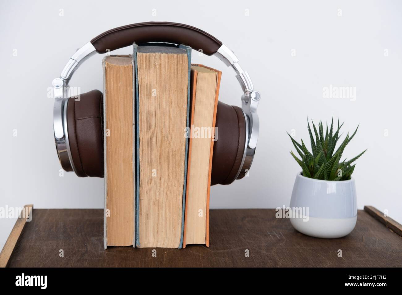 pila di libri con cuffie, apprendimento di lingue straniere con audiobook, apprendimento multimediale, sviluppo di capacità di lettura e ascolto, tecnologia Foto Stock