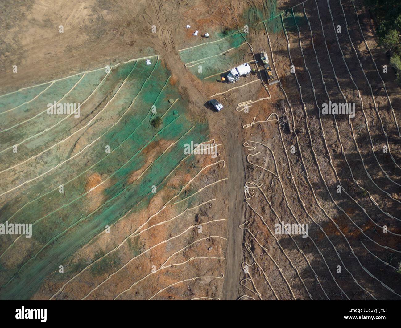 Wattles di paglia posti su una collina come controllo dell'erosione in un cantiere edile e idrosemina in California, Stati Uniti, visti da una vista aerea tramite drone. Foto Stock