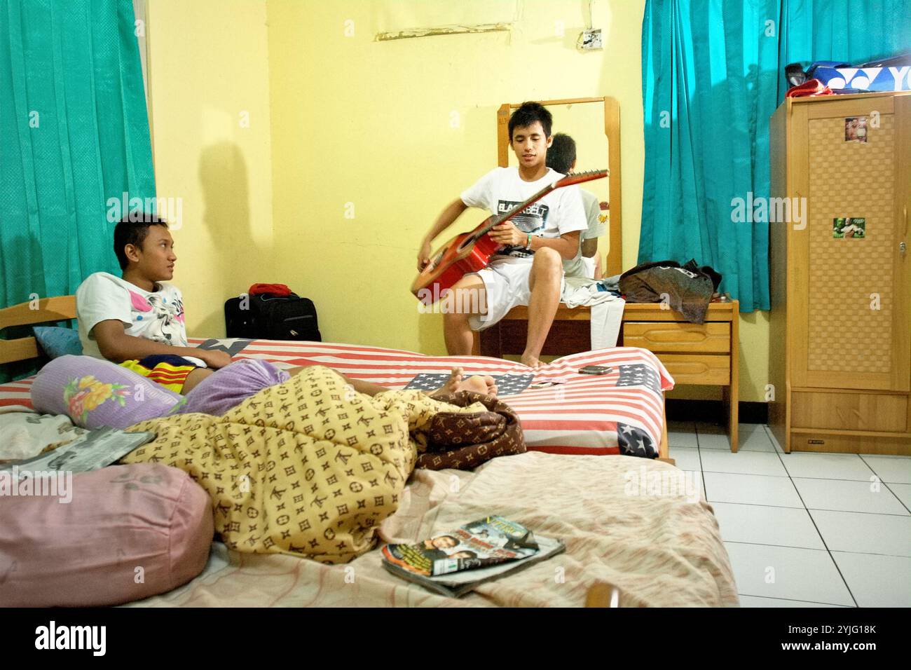 Giovani atleti di badminton che si rilassano in una stanza in disordine dopo una sessione di allenamento al club Jaya Raya badminton di Giacarta, Indonesia. Foto Stock