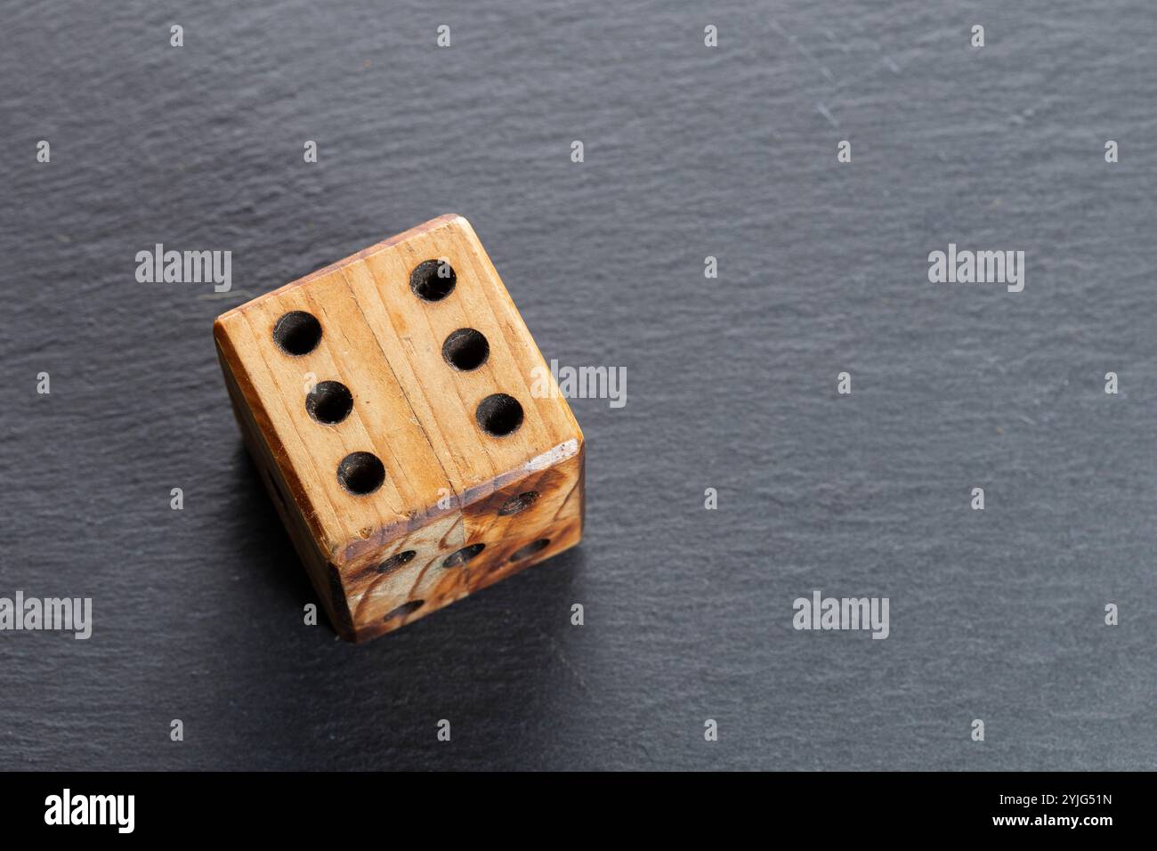 Una matrice di legno, con il numero sei in alto, è mostrata su un'ardesia grigia Foto Stock