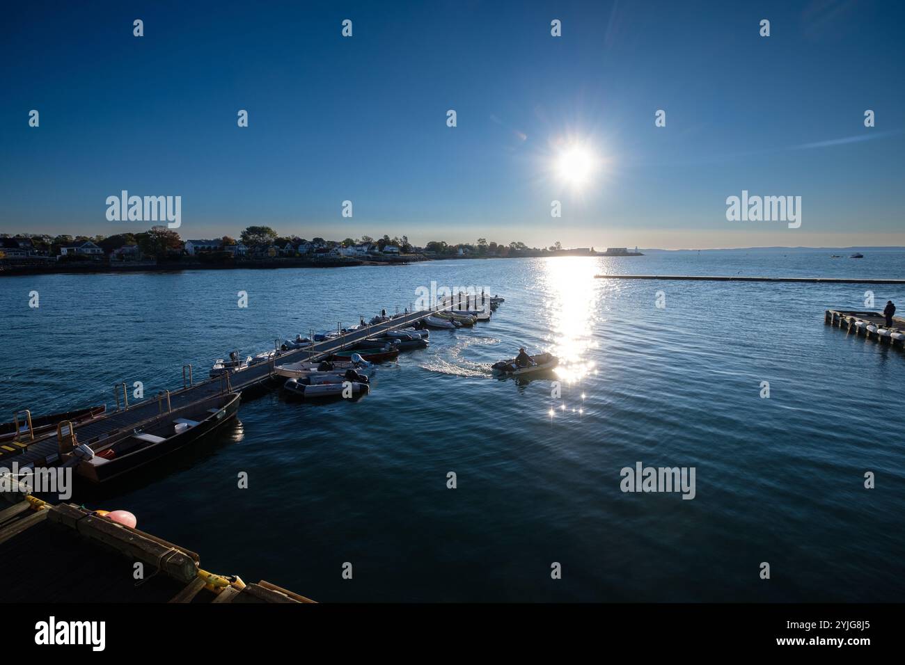 Il sole sorge sul fiume St. Croix e sul porto di St. Andrews, New Brunswick, Canada, nelle province martime del Canada, mentre una piccola barca si allontana. Foto Stock