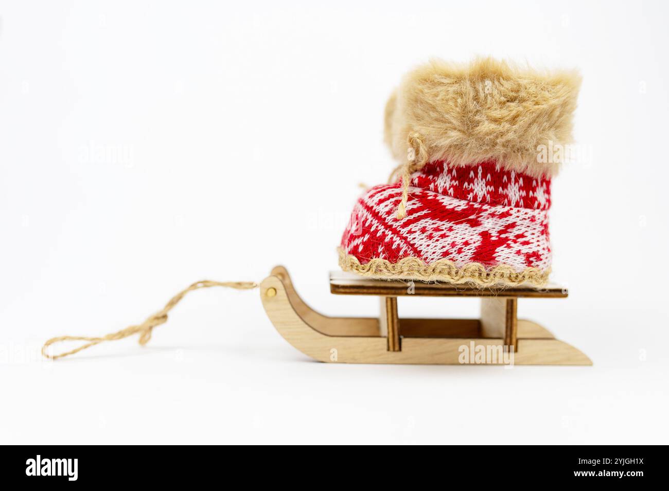 Decorazione concettuale. Red Nicholas Christmas su stivali Sled isolati su sfondo bianco. Stivali invernali, stivali da neve. Anno nuovo. LA SCARPA NAZIONALE È LA GIORNATA DEL MONDO Foto Stock