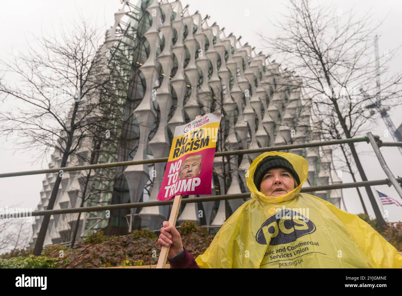 Londra, Regno Unito. 20 gennaio 2018. Paula Peters del DPAC ha un cartello di fronte all'ambasciata degli Stati Uniti di recente apertura a Nine Elms. Stand Up to Racism's Protestation è stata la prima su questo sito e si è svolta sotto una pioggia costante. Era l'anniversario dell'inaugurazione del presidente Trump, un anno che si è concluso con i suoi commenti chiaramente razzisti che descrivevano le nazioni africane, Haiti ed El Salvador come "shitholes”, il che ha causato offesa e indignazione in tutto il mondo. La campagna di Trump e il primo anno in carica sono stati segnati da attacchi razzisti contro comunità nere, migranti, rifugiati e comunità musulmana e h Foto Stock
