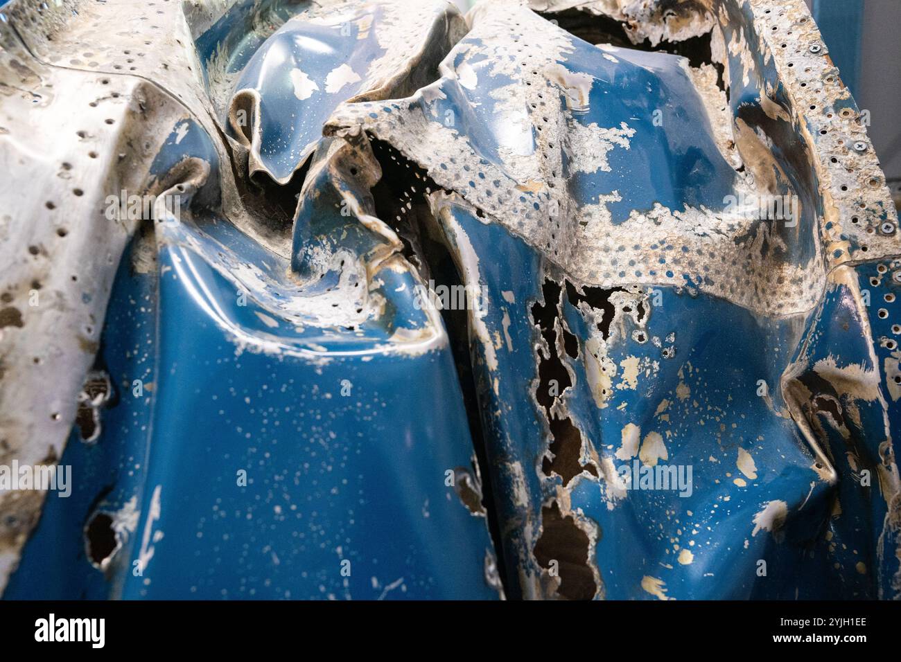 Contenitori in plastica blu intemprati che mostrano degrado e deterioramento a causa dell'esposizione Foto Stock