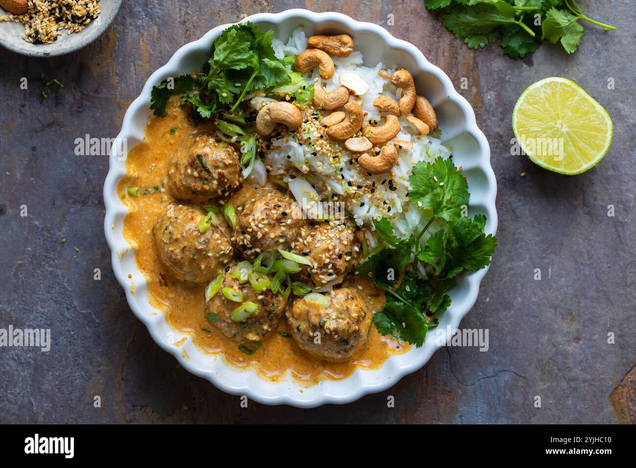 Polpette di tacchino in salsa tailandese al curry con riso, coriandolo e anacardi Foto Stock