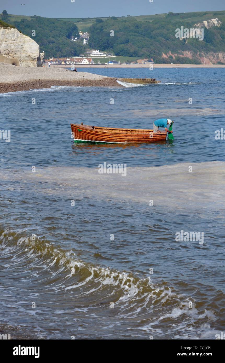 l'uomo solitario che si reca in un piccolo clinker costruisce la tradizionale birra dinghy devon england Foto Stock