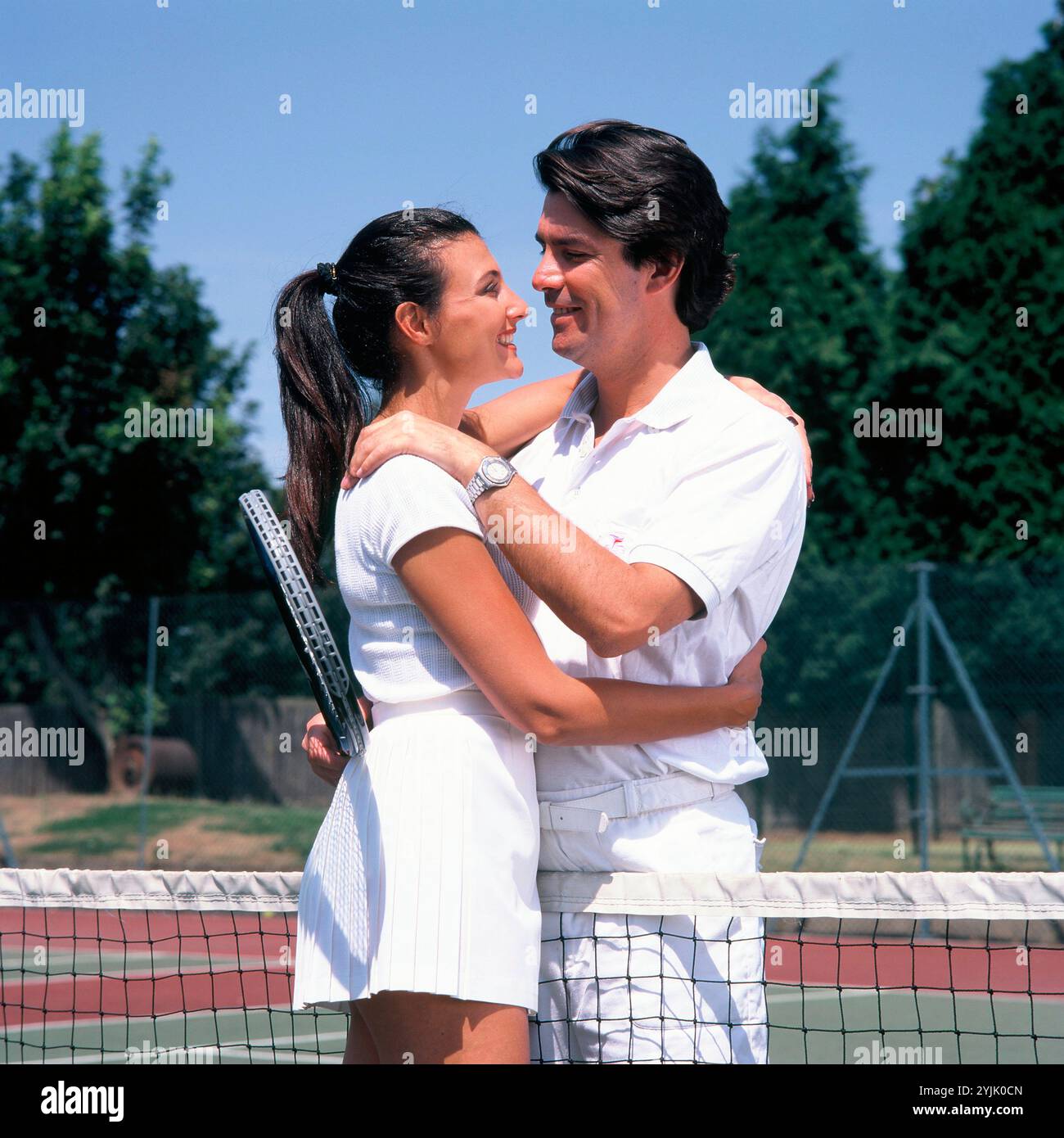 Stile di vita. Sport. Giovane coppia che abbraccia il campo da tennis. Foto Stock