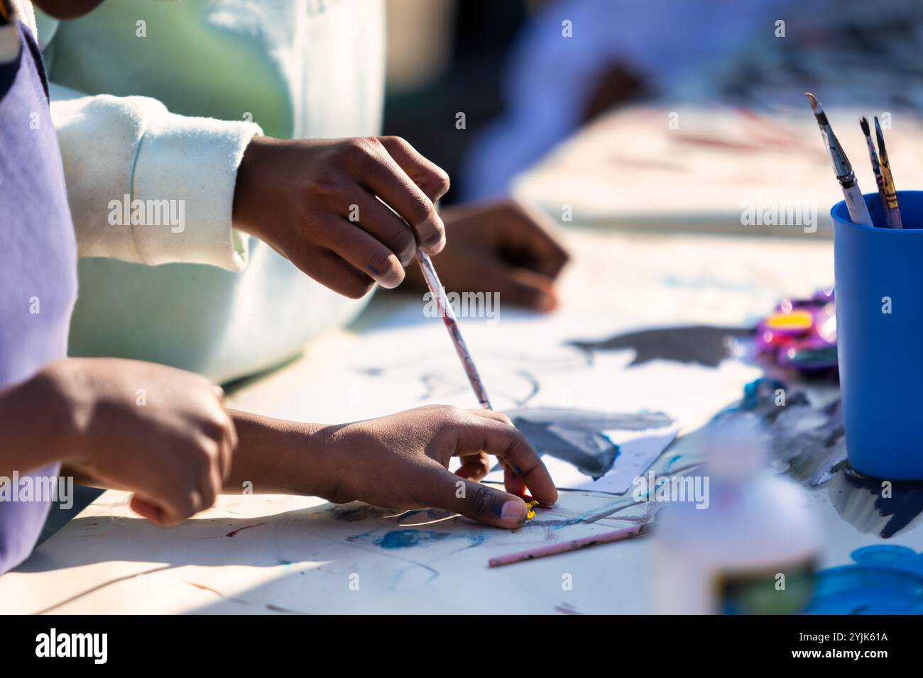 Bambini africani con un pennello dipinto su carta all'aperto, pittura a mano, pittura Foto Stock