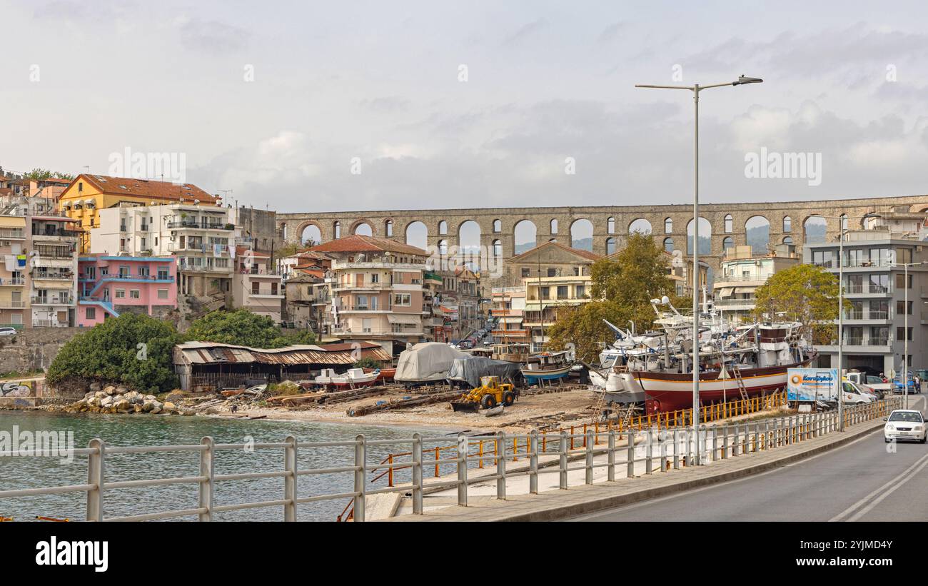 Kavala, Grecia - 22 ottobre 2023: Antica struttura dell'acquedotto romano con vista sul molo di carenaggio della Marina Vecchia nel giorno dell'autunno. Foto Stock