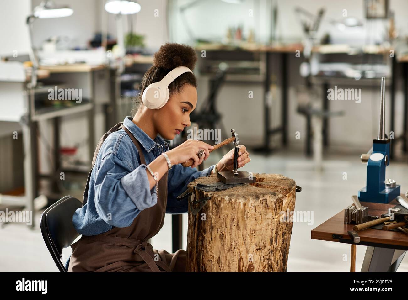 Una designer di talento si concentra sulla creazione di splendidi gioielli mentre si diverte con il suo mestiere. Foto Stock