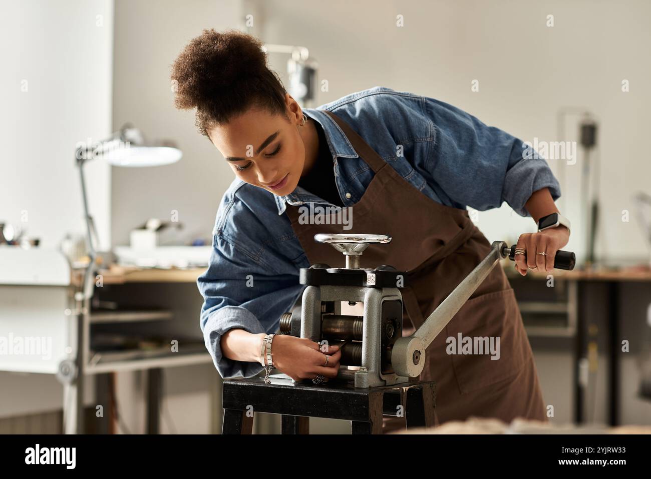 L'abile artigiana crea gioielli con strumenti specializzati nel suo spazio creativo. Foto Stock