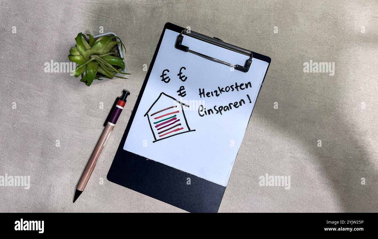 Concetto di Heizkosten Einsparen sulla lingua tedesca scrivere su documenti isolati su un tavolo di legno. Tedesco significa risparmiare sui costi di riscaldamento Foto Stock