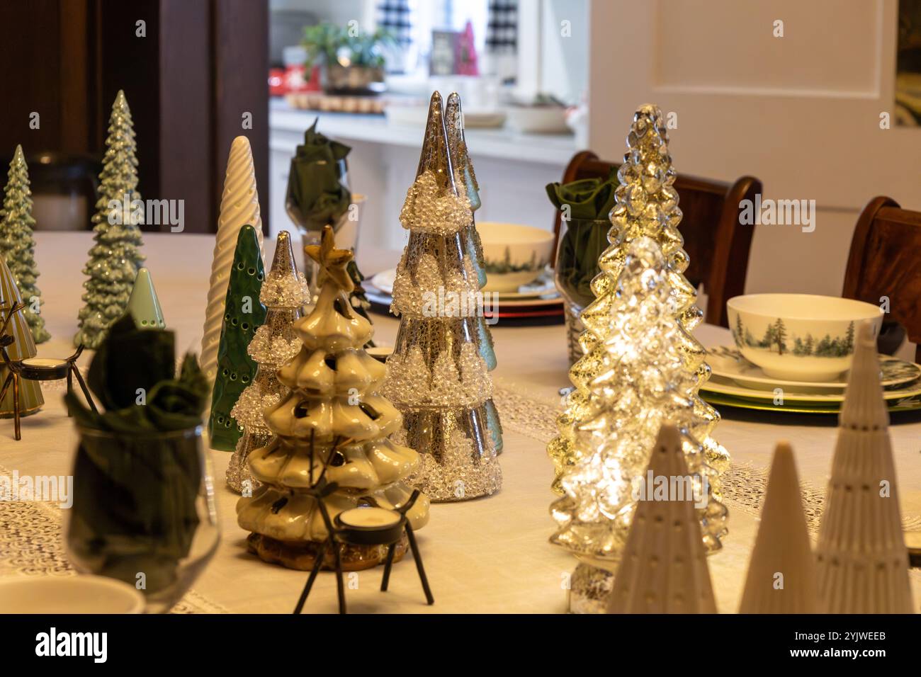 Sfondo a struttura astratta con un accogliente tavolo da pranzo con decorazioni assortite per le feste con alberi di Natale e candele Foto Stock