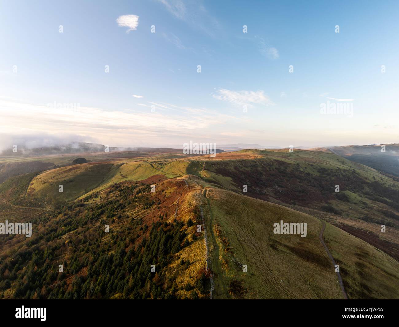 Splendida vista aerea di un colorato paesaggio autunnale con nuvole basse, nebbia e sole al tramonto Foto Stock