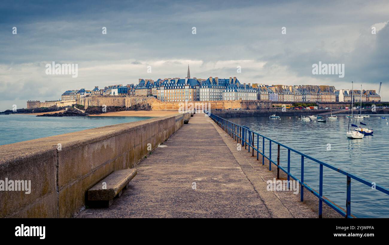 Vista della città vecchia di Saint Malo, Bretagna, Francia, conosciuta come "Intra Muros", dalla diga, sotto un cielo nuvoloso Foto Stock