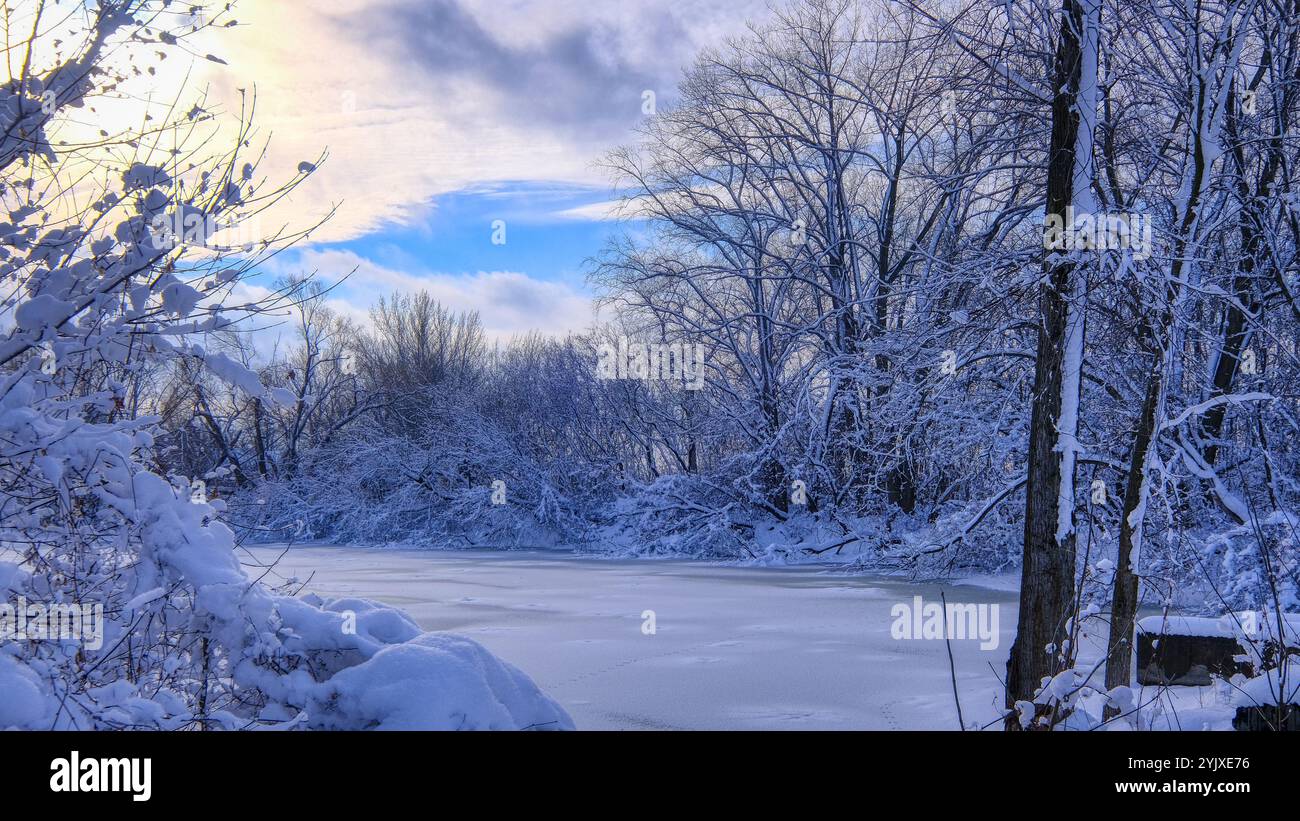 fotografia di un paesaggio invernale del fiume ghiacciato nel mezzo della foresta con abbondante neve. sfondo del desktop, visualizzazione orizzontale 16:9. Foto Stock