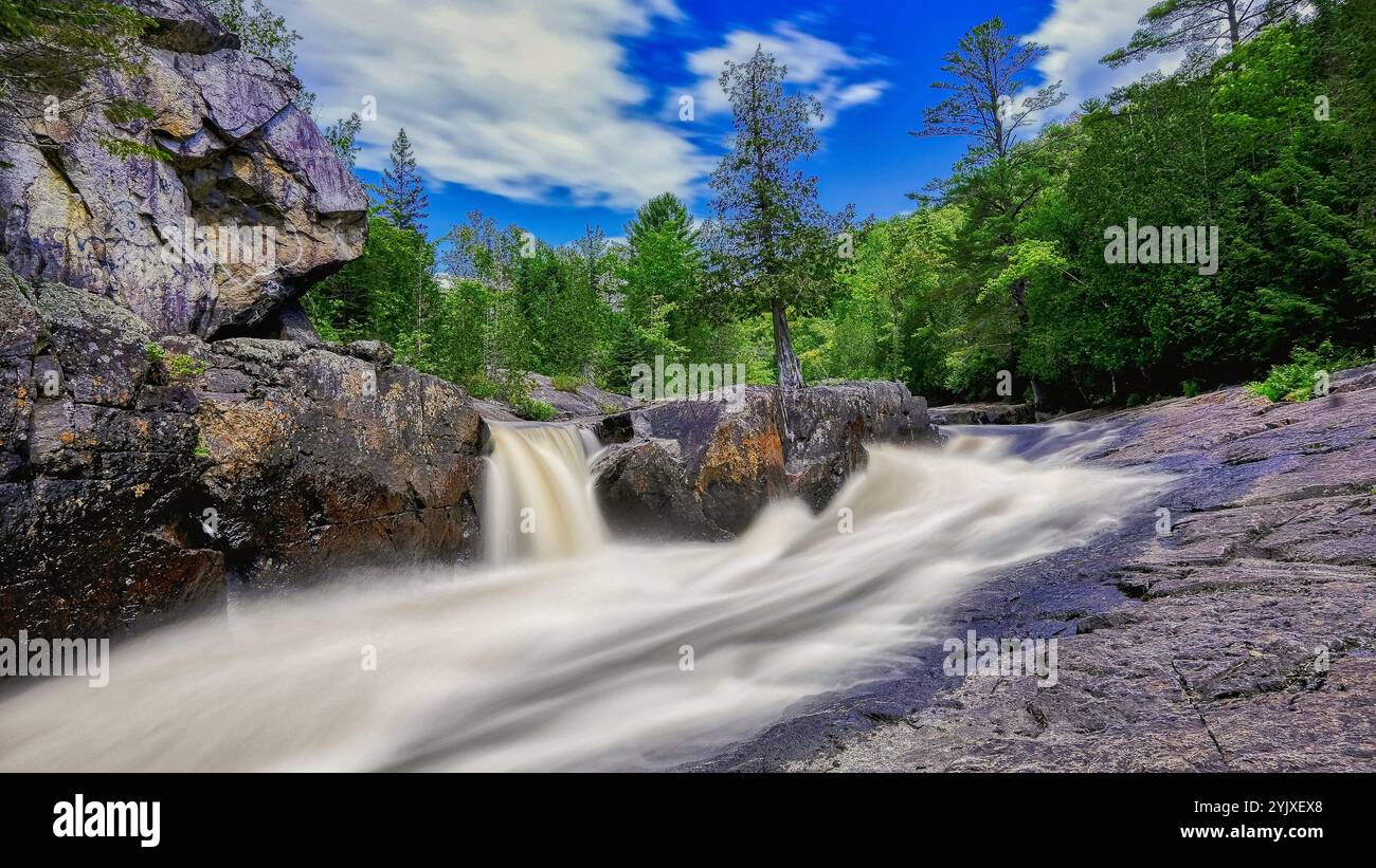 grande cascata in un giorno di cielo blu nella foresta. sfondo del desktop, visualizzazione orizzontale 16:9. Foto Stock