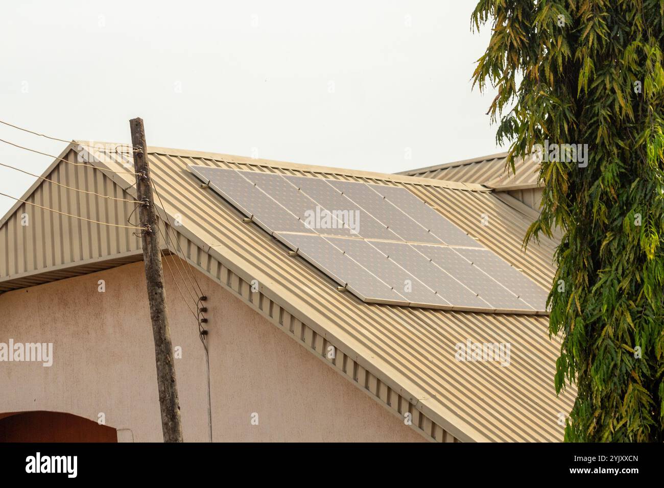 pannelli solari su tetti metallici di edifici residenziali che indicano una rivoluzione verde tra le abitazioni urbane africane nel xxi secolo Foto Stock