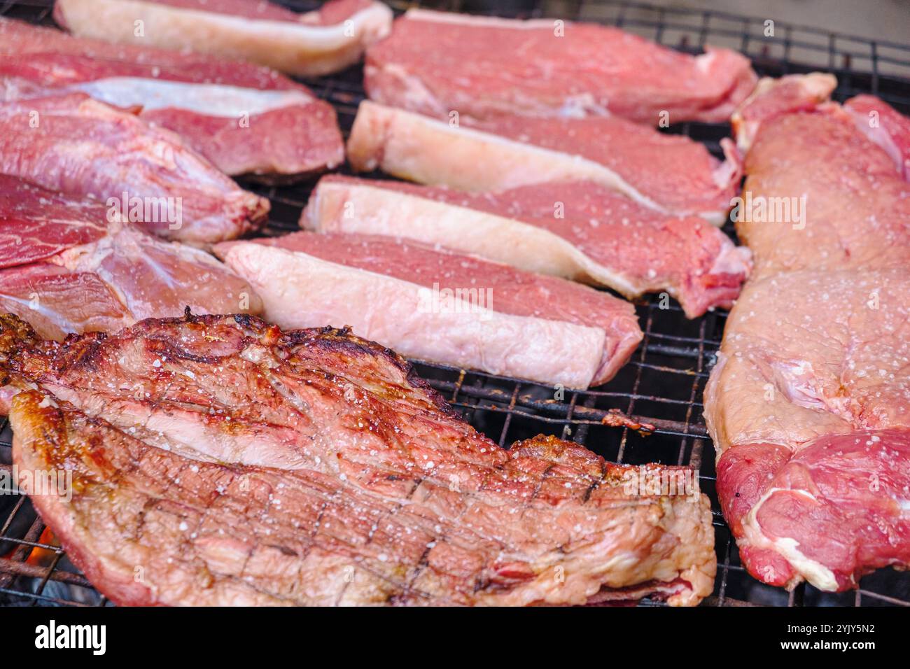pezzi di manzo crudo cucinati su una griglia Foto Stock