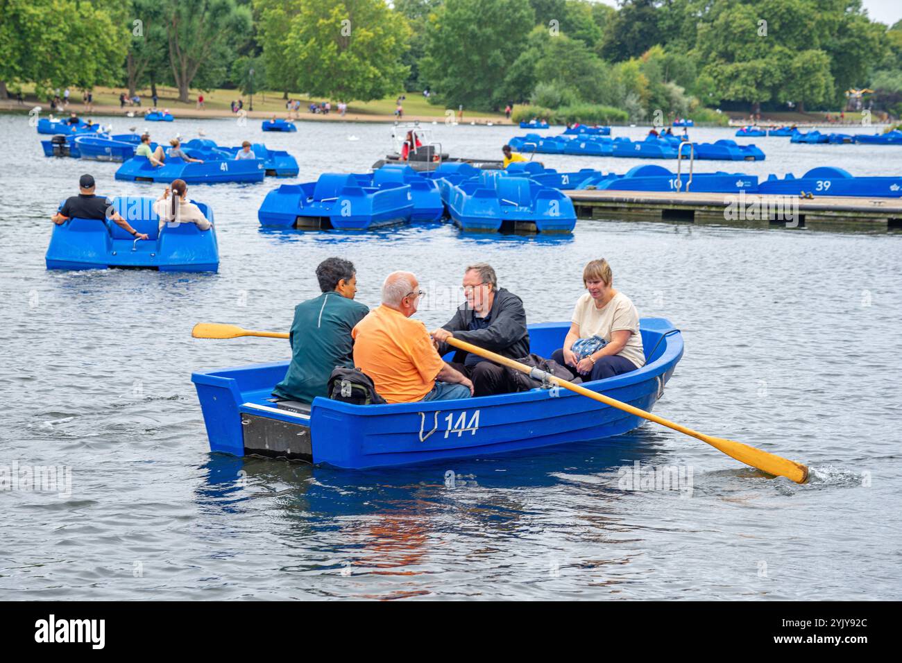 Persone anziane che vogano piccole imbarcazioni ricreative sul lago Hyde Park Serpentine nel centro della città britannica di Londra.UK. Foto Stock