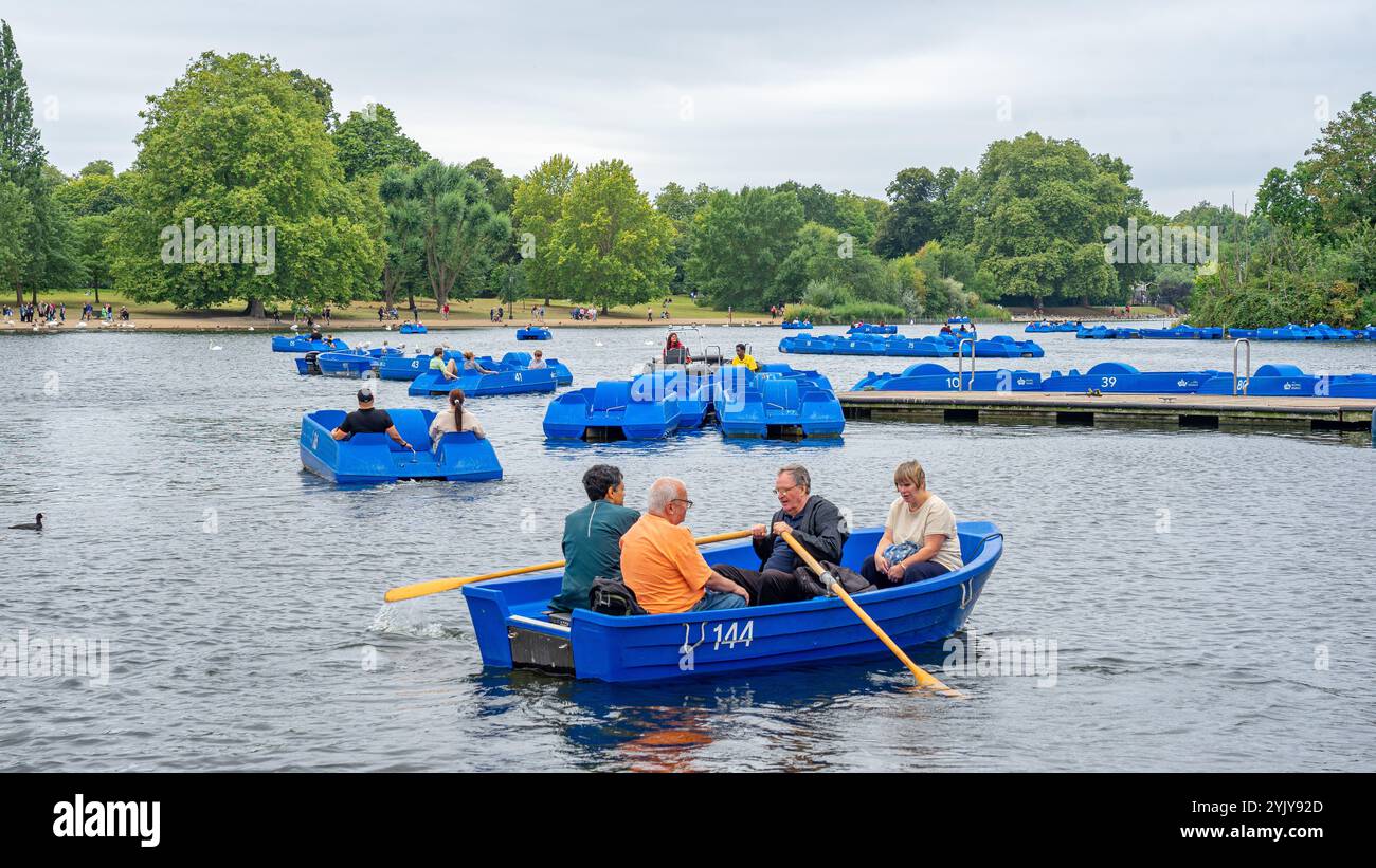 Persone anziane che vogano piccole imbarcazioni ricreative sul lago Hyde Park Serpentine nel centro della città britannica di Londra.UK. Foto Stock