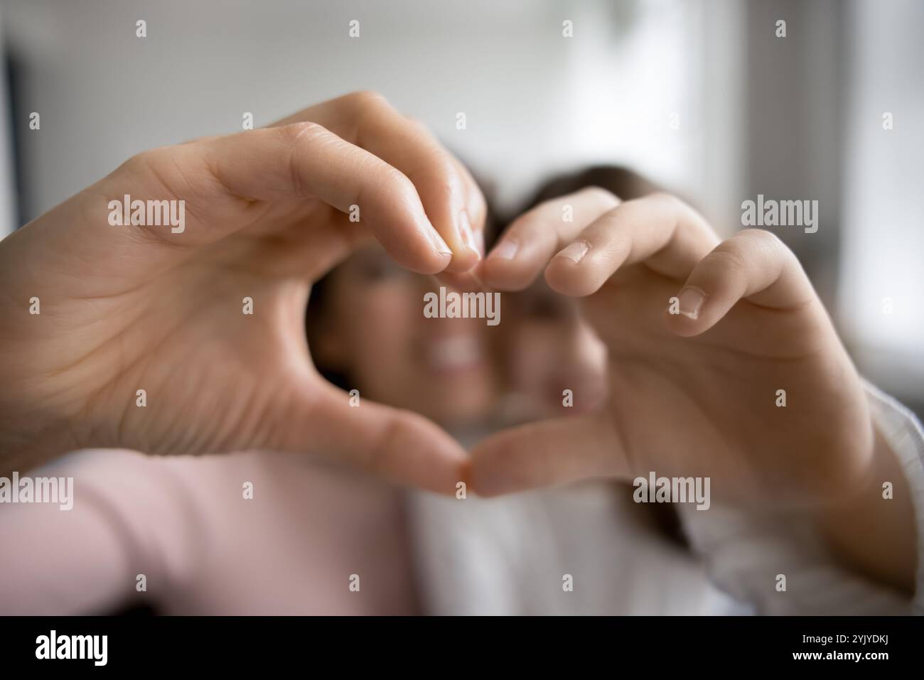 Primo piano due persone che mostrano il simbolo del cuore con le dita unite Foto Stock