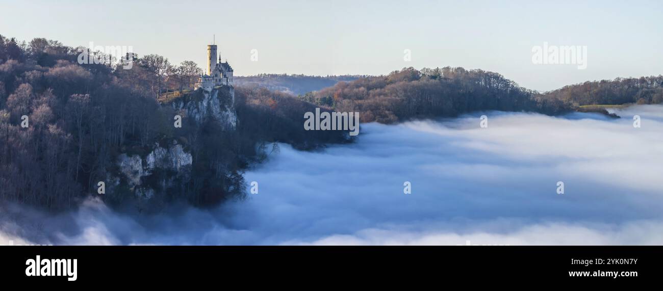 Sole sulle montagne, nebbia nella valle di Echaz. Castello di Lichtenstein nell'alb. Svevo. Il castello fiabesco di Wuerttemberg è un cas del XIX secolo Foto Stock