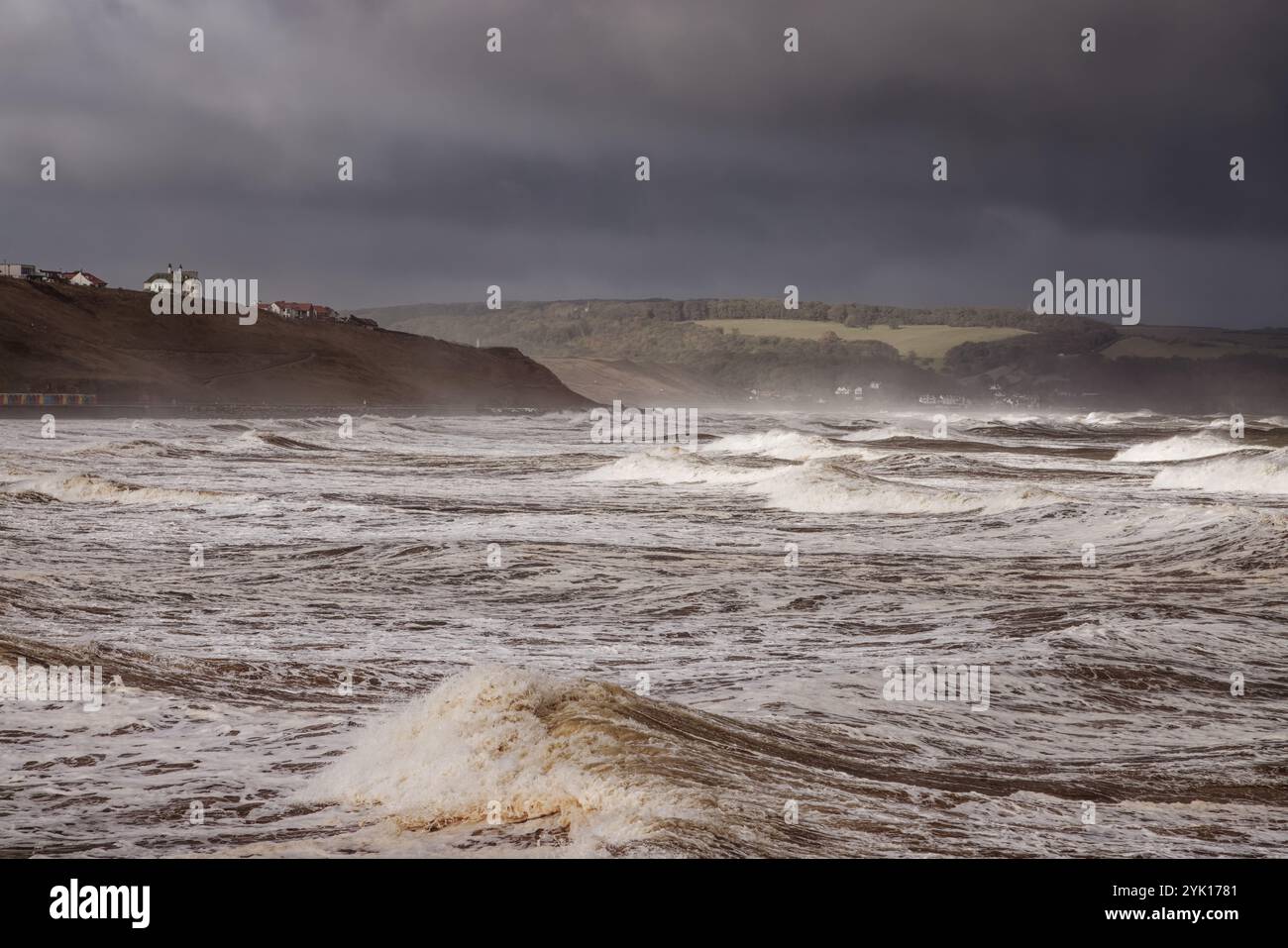 I mari scoscesi colpiscono le scogliere di Whitby, North Yorkshire, Inghilterra. Foto Stock