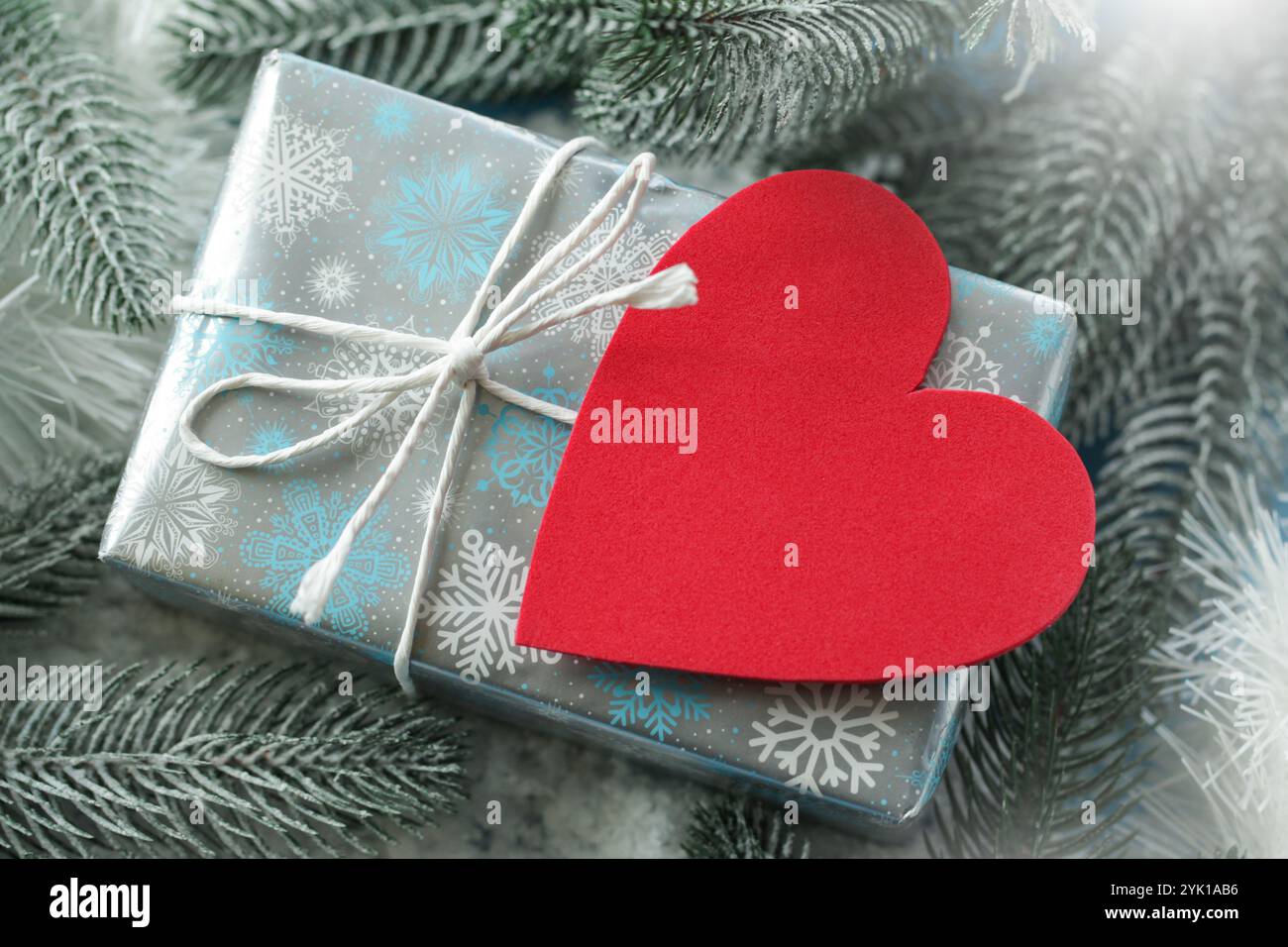 Confezione regalo, vuota, cuore sul ramo della neve. Regali invernali. Concetto di San Valentino, matrimoni, compleanno, giorno del papà o della mamma Foto Stock