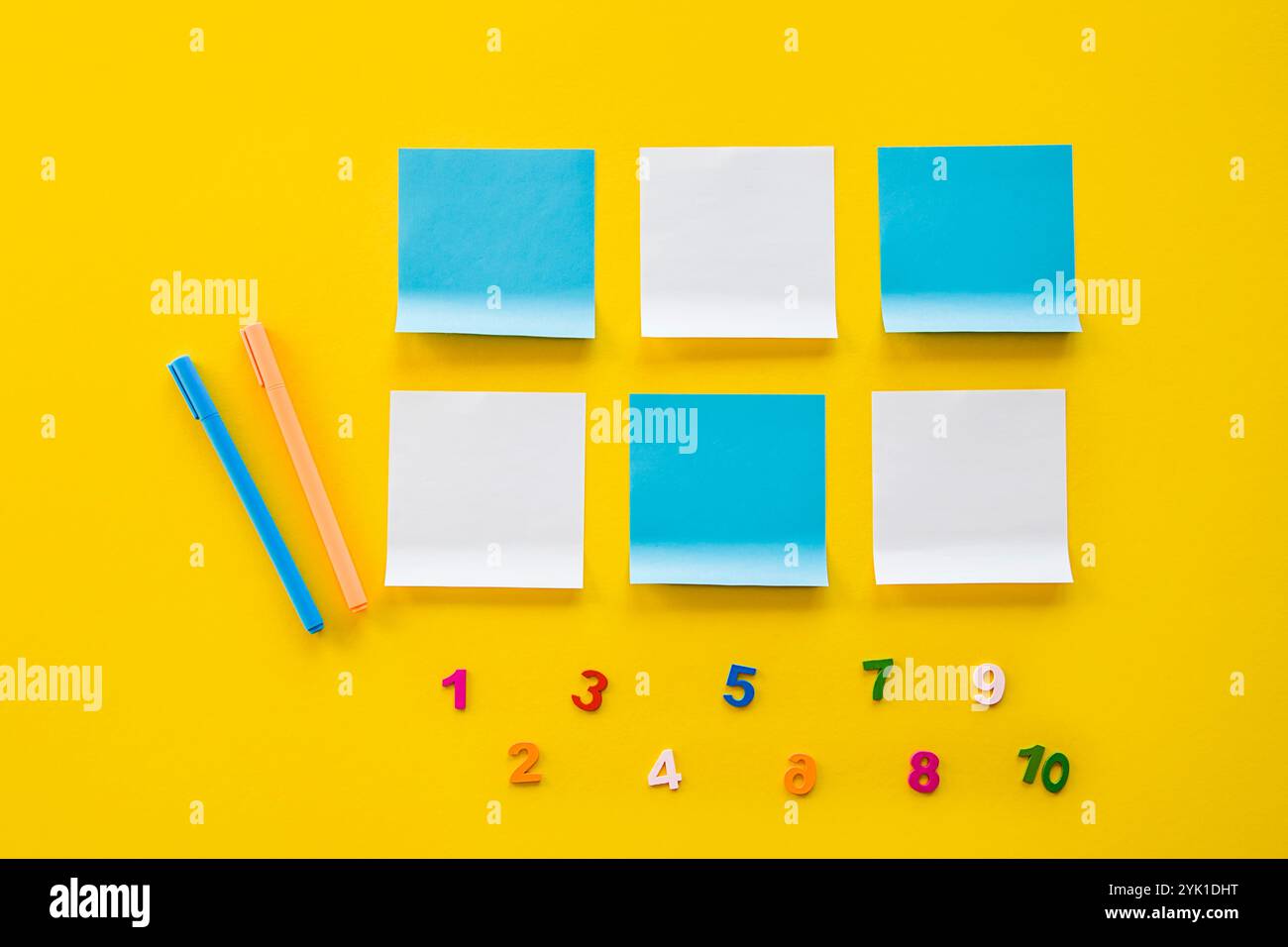Adesivo di ritorno al concetto di scuola. Vista dall'alto delle forniture scolastiche su sfondo giallo spazio vuoto per il testo. Letto piatto di asilo o di forniture scolastiche. Foto Stock