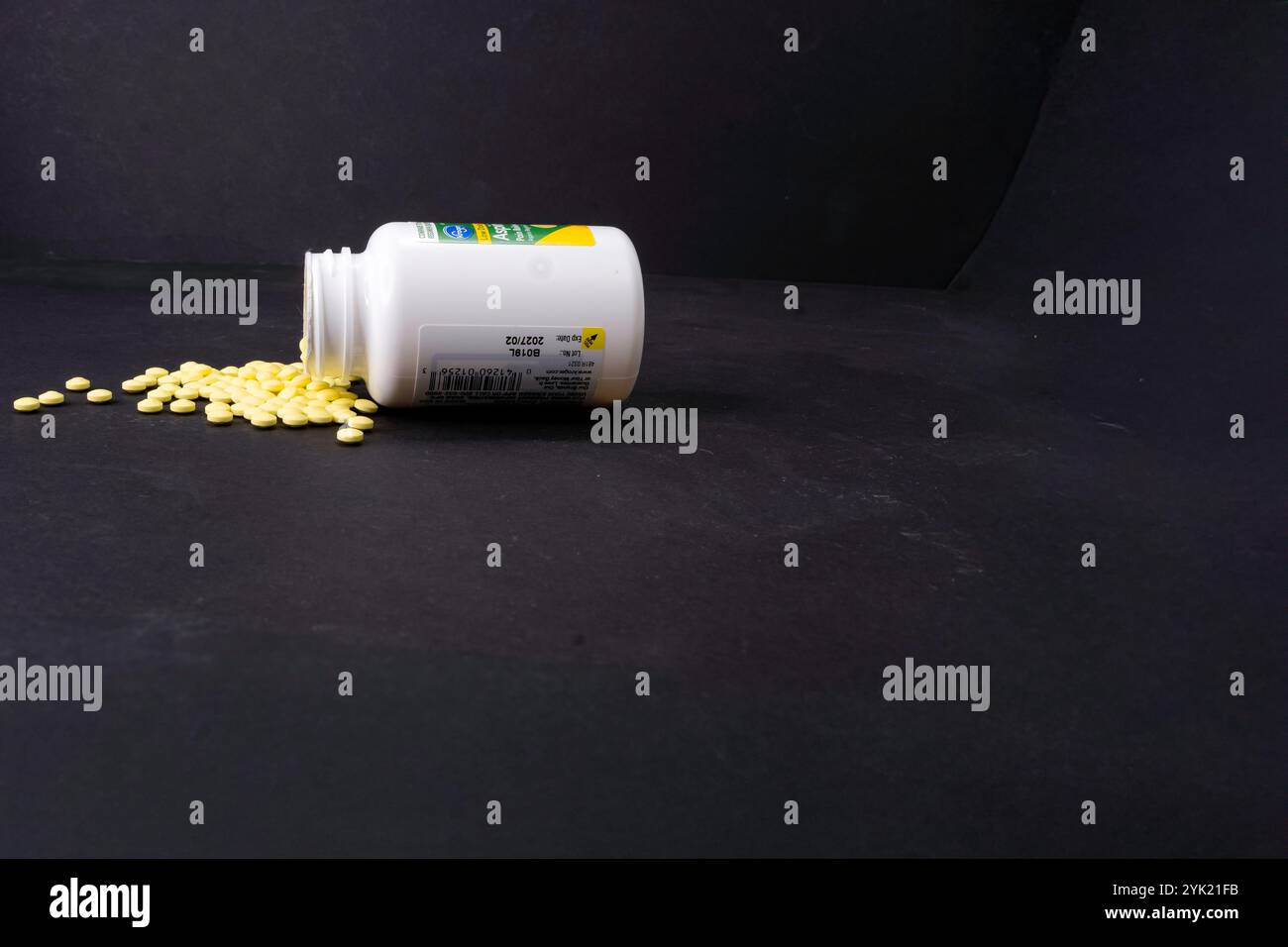 Un contenitore di aspirina è stato rovesciato e l'aspirina del bambino è stata rovesciata. Foto Stock