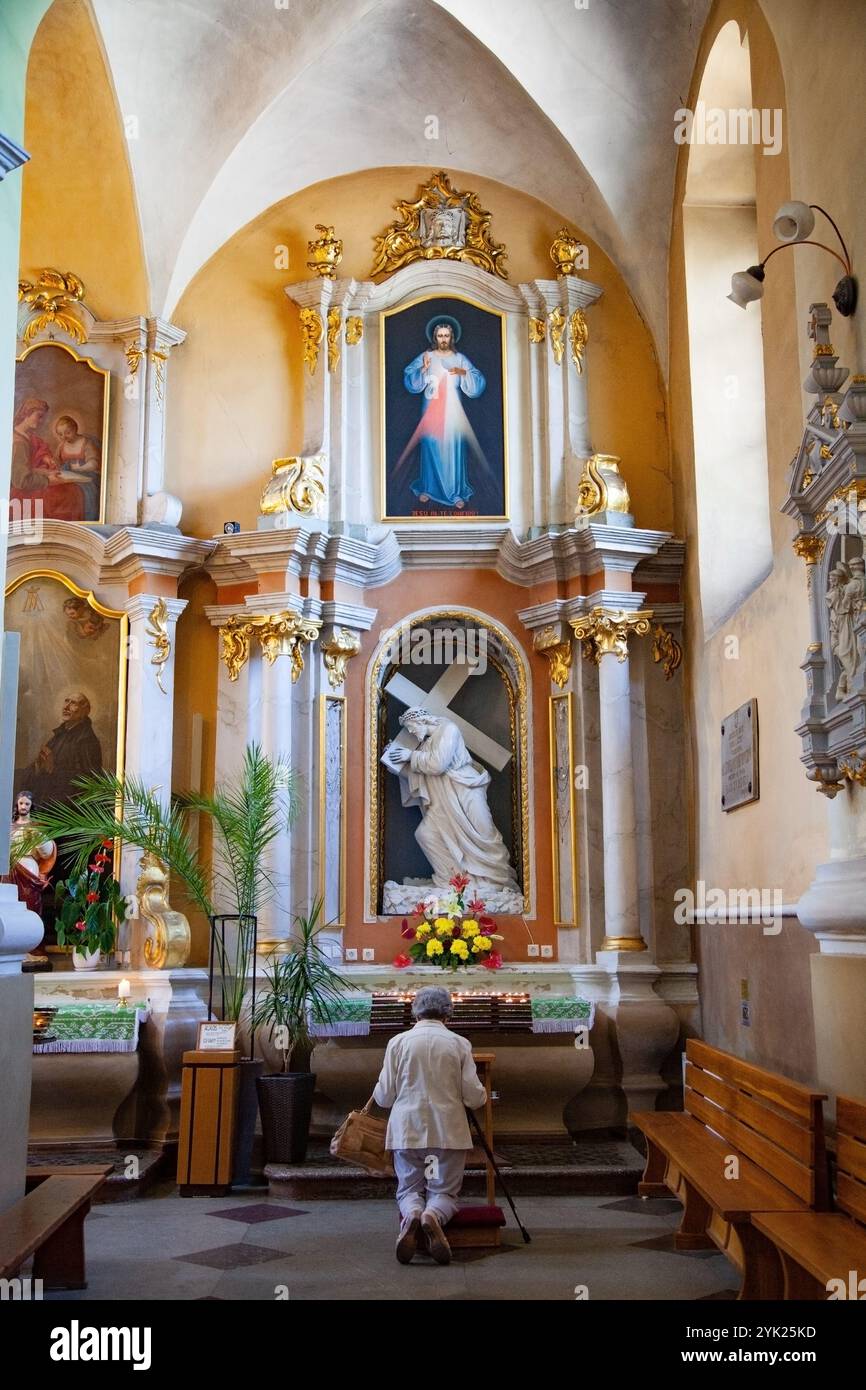 Vilnius, Lituania - 7 luglio 2017 - donna in preghiera nella chiesa cattolica di San Raffaello e nel monastero dei Gesuiti Foto Stock