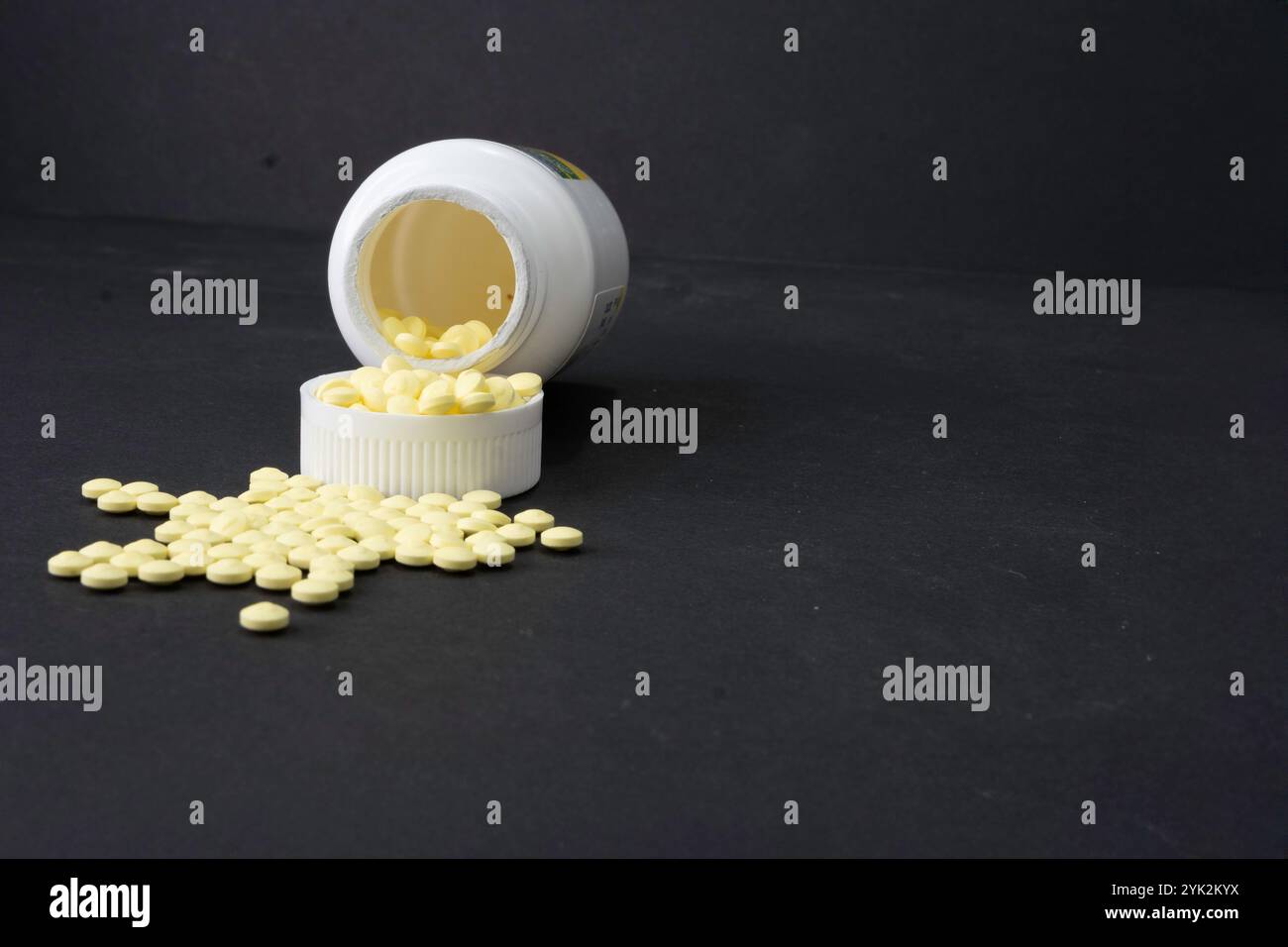 Un contenitore di aspirina bassa si rovescia e l'aspirina del bambino fuoriesce. Foto Stock